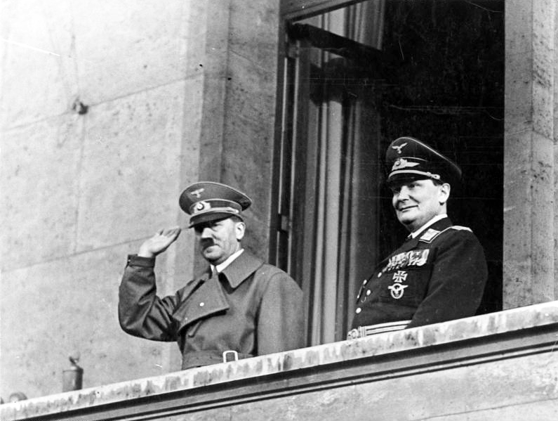 Adolf Hitler and Hermann Göring salute the crowd from the chancellery balcony at his return after the Anschluss
